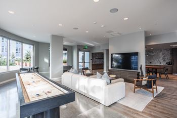 a large living room with a white couch and a pool table